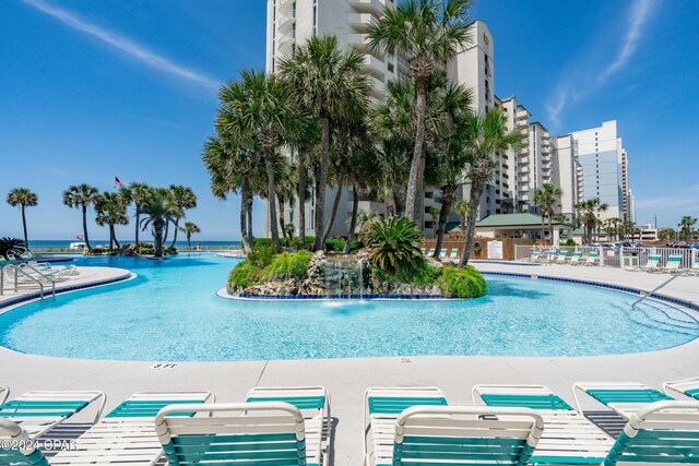 view of swimming pool with pool water feature and a water view