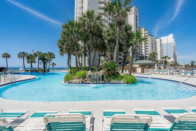 view of swimming pool with pool water feature and a water view