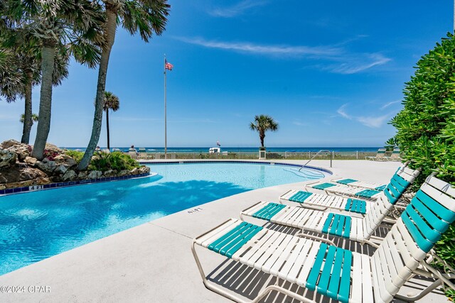 view of swimming pool with a water view and a patio