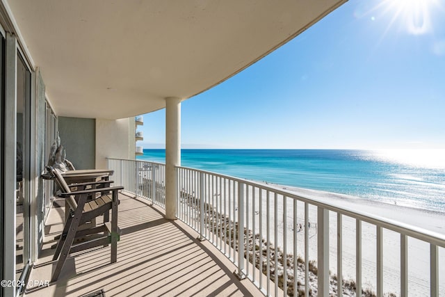 balcony featuring a water view and a view of the beach