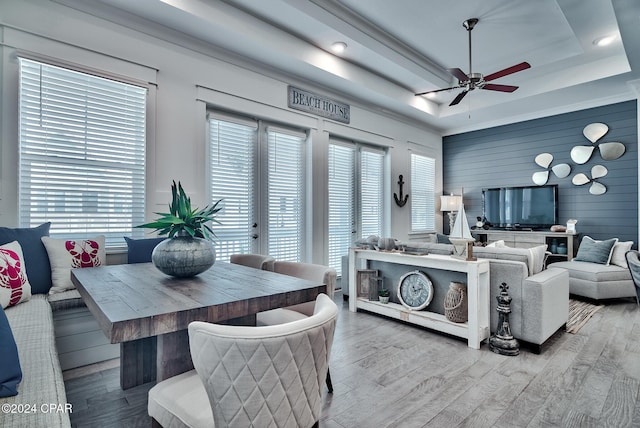 living room featuring ceiling fan, hardwood / wood-style floors, and a tray ceiling