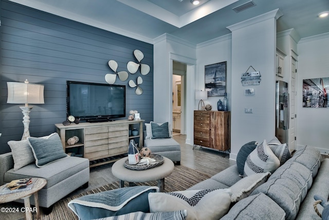 living room featuring crown molding, wooden walls, and hardwood / wood-style floors