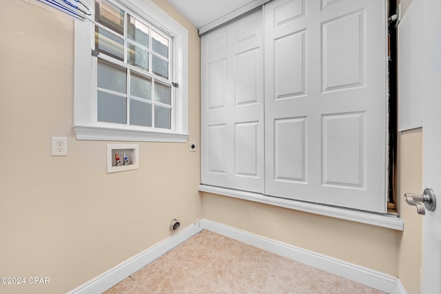 clothes washing area with hookup for a washing machine and light tile patterned floors