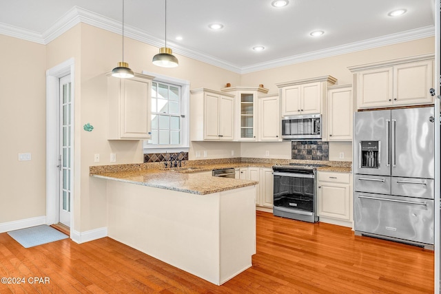 kitchen featuring appliances with stainless steel finishes, light hardwood / wood-style floors, ornamental molding, decorative light fixtures, and kitchen peninsula