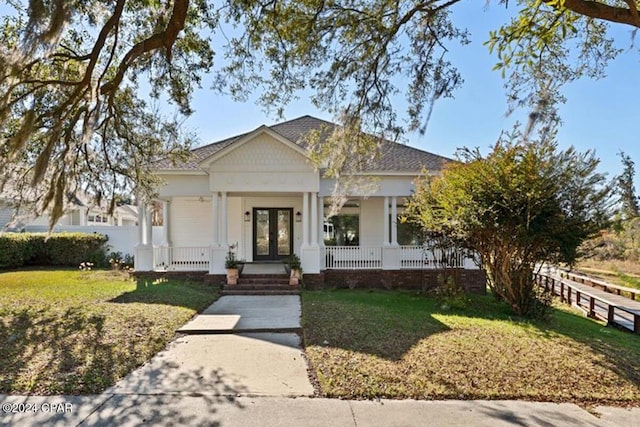 view of front facade with a porch, a front yard, and french doors