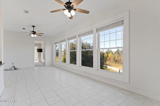 unfurnished sunroom with ceiling fan