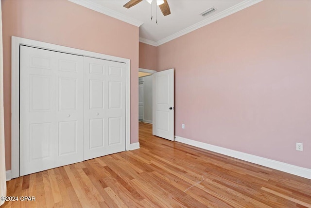 unfurnished bedroom with ceiling fan, a closet, light hardwood / wood-style floors, and ornamental molding