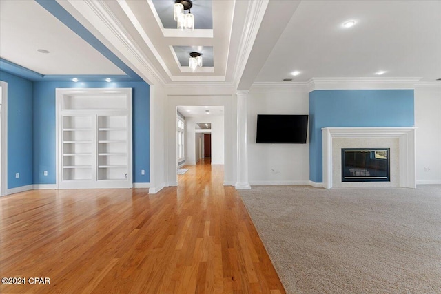 unfurnished living room featuring built in shelves, light wood-type flooring, ornamental molding, and a fireplace