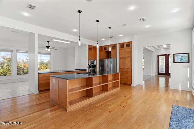 kitchen with ceiling fan, sink, pendant lighting, a kitchen island with sink, and appliances with stainless steel finishes