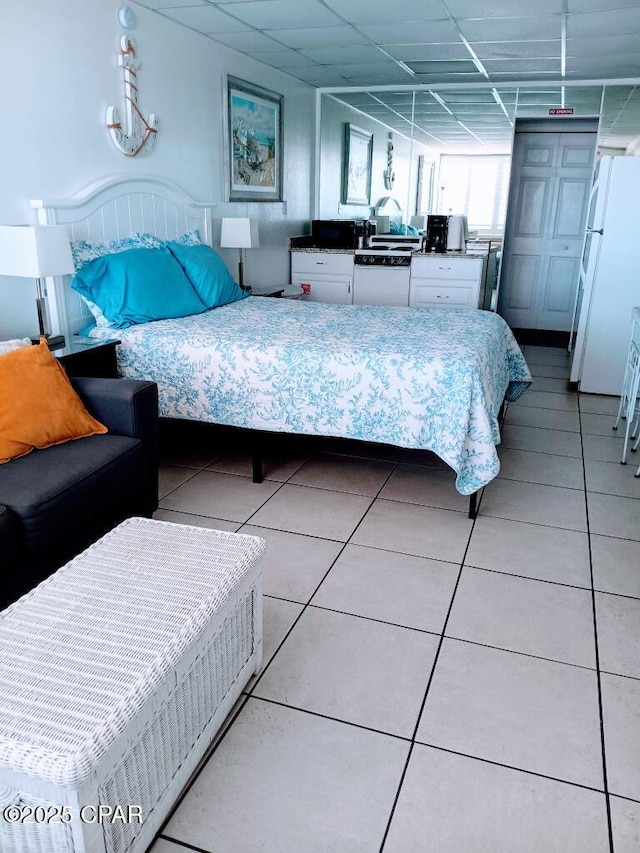 bedroom with tile patterned flooring and white fridge