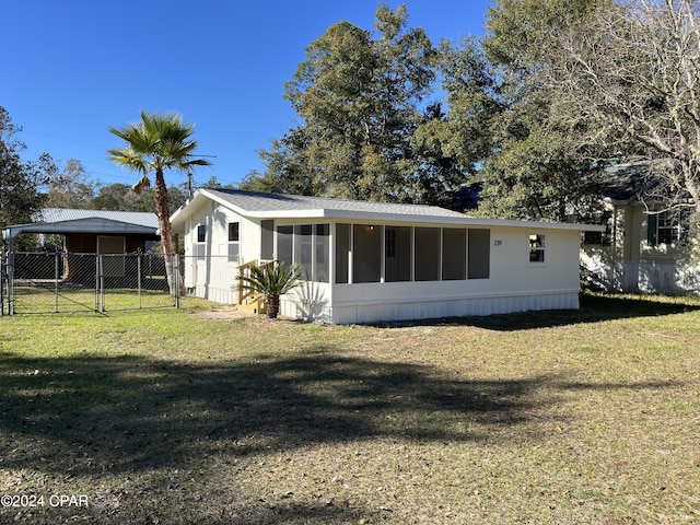 back of house with a sunroom and a yard