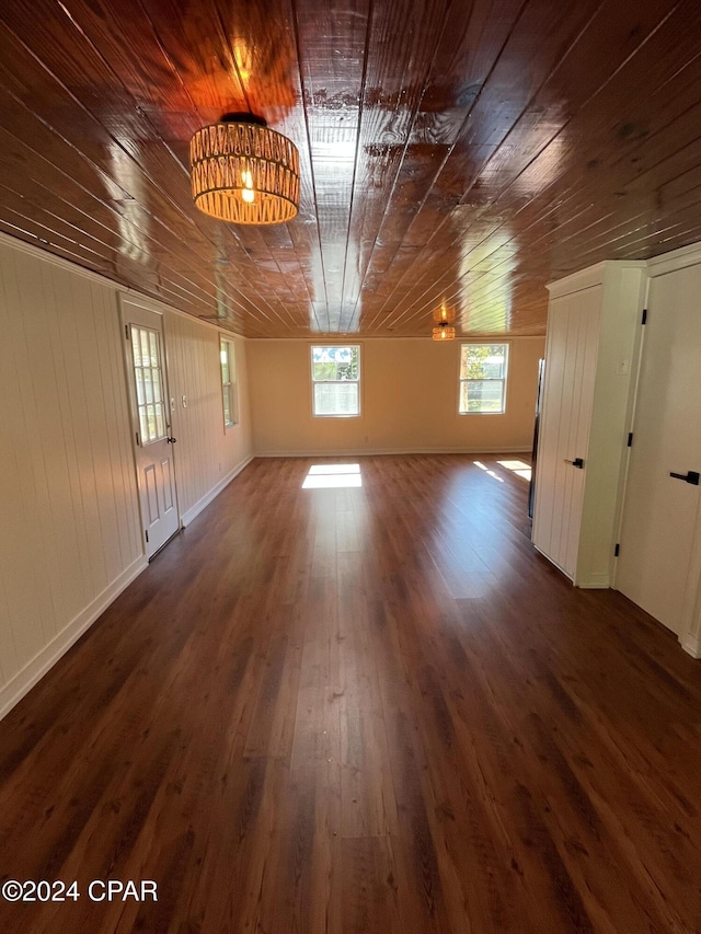 spare room featuring dark hardwood / wood-style floors and wooden ceiling