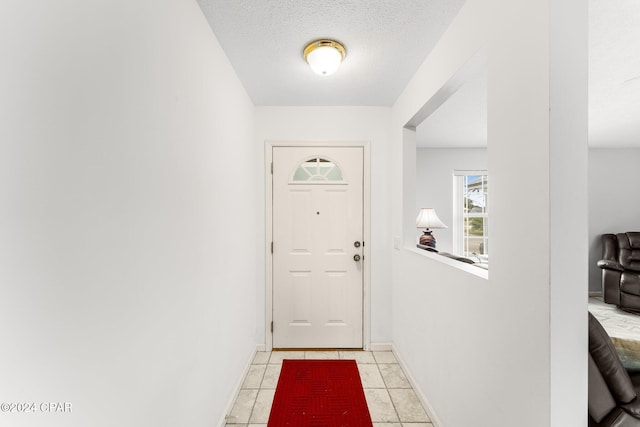 doorway to outside with light tile patterned floors