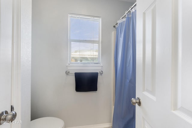 bathroom with a shower with curtain and toilet