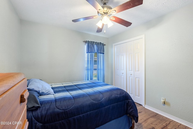 bedroom with hardwood / wood-style floors, a textured ceiling, a closet, and ceiling fan