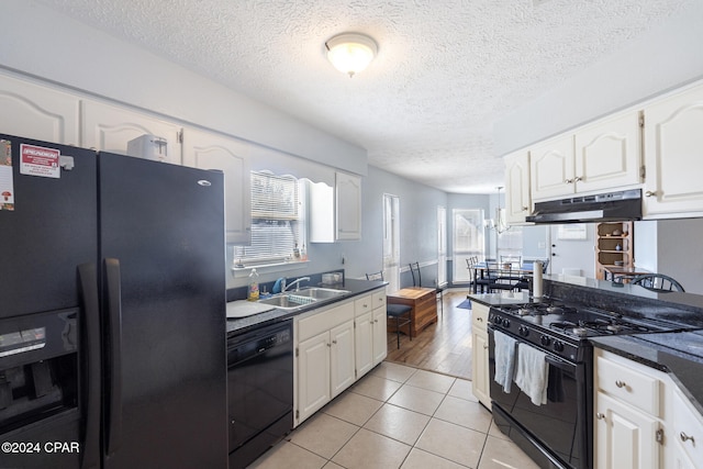 kitchen with black appliances, white cabinetry, and sink