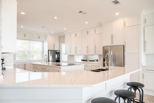 kitchen with white cabinets, stainless steel fridge, stainless steel refrigerator, and a spacious island