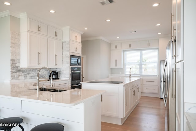 kitchen featuring a center island, white cabinets, built in microwave, and sink