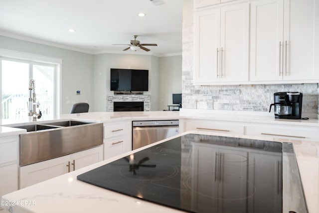 kitchen with sink, white cabinetry, stainless steel dishwasher, and black electric stovetop