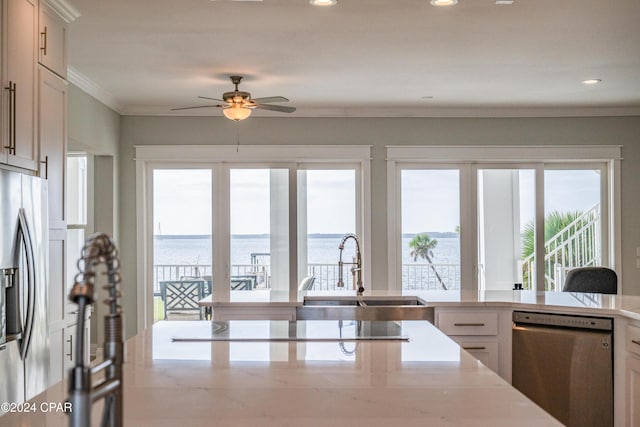 kitchen with white cabinetry, ceiling fan, appliances with stainless steel finishes, a water view, and sink