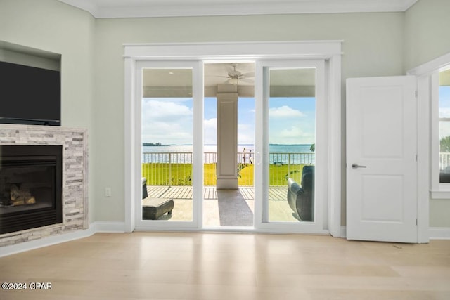 doorway featuring ceiling fan, light hardwood / wood-style floors, and a water view