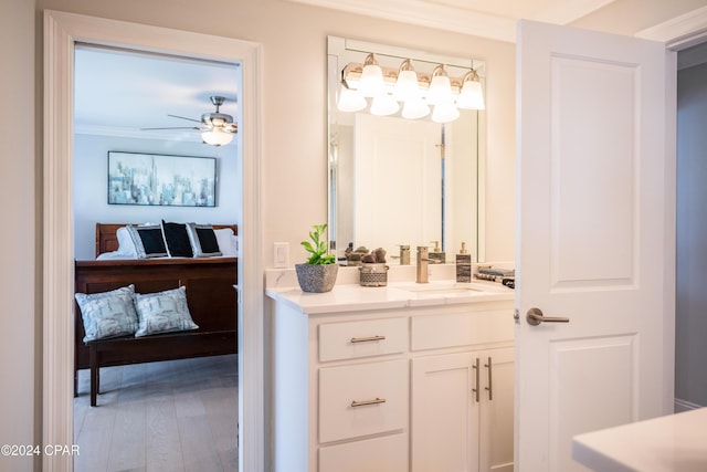 bathroom featuring hardwood / wood-style flooring, vanity, crown molding, and ceiling fan