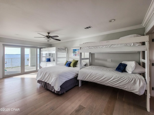 bedroom with ceiling fan, a water view, hardwood / wood-style flooring, and access to outside