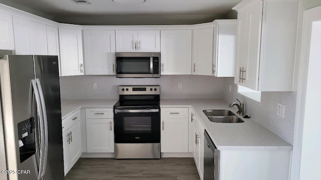 kitchen with sink, white cabinets, stainless steel appliances, and tasteful backsplash