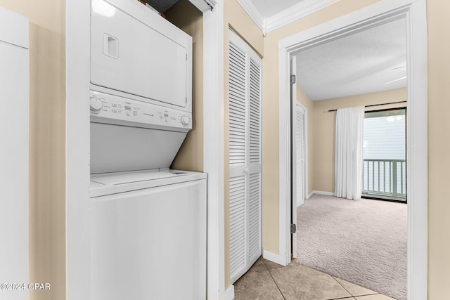 laundry room with crown molding, light carpet, stacked washer and dryer, and a textured ceiling