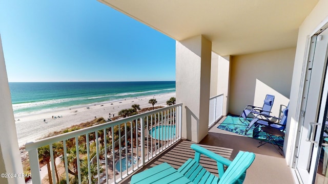 balcony featuring a water view and a beach view