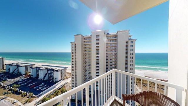 balcony featuring a water view and a beach view