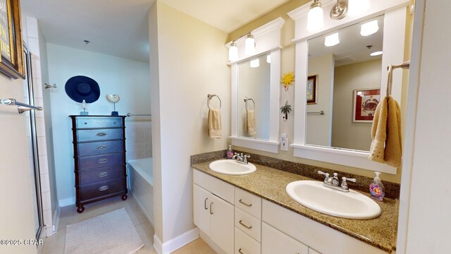 bathroom featuring a tub to relax in, tile patterned floors, and vanity