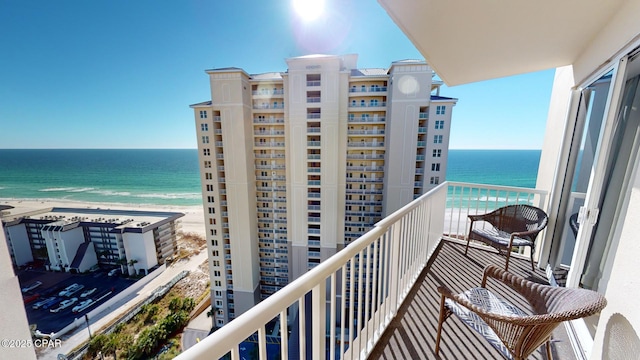 balcony featuring a beach view and a water view