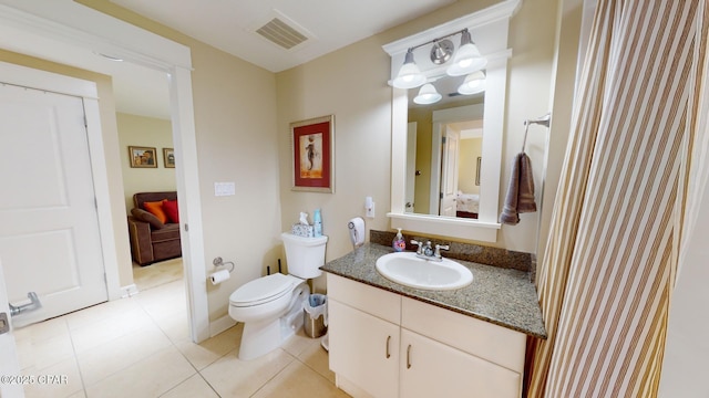 bathroom featuring tile patterned flooring, vanity, and toilet