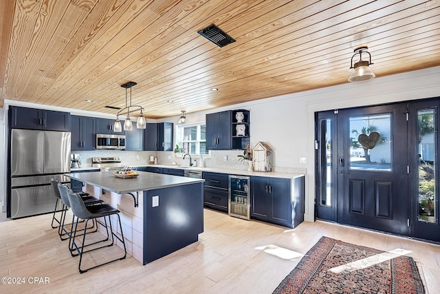 kitchen with a center island, wooden ceiling, wine cooler, appliances with stainless steel finishes, and decorative light fixtures