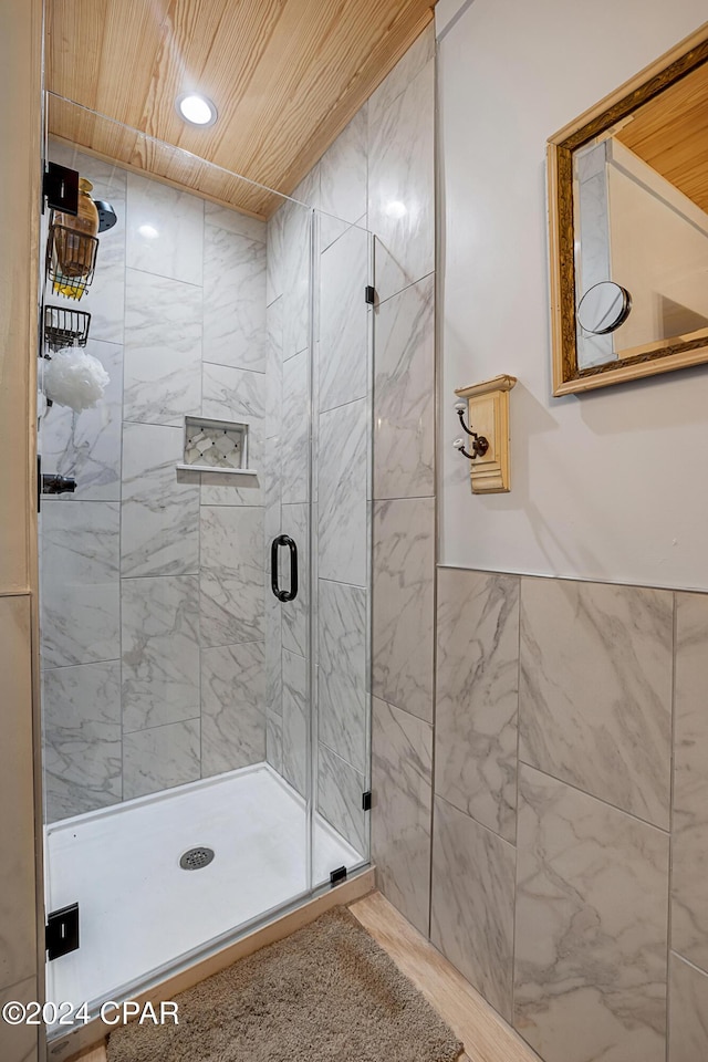 bathroom with a shower with door and wooden ceiling