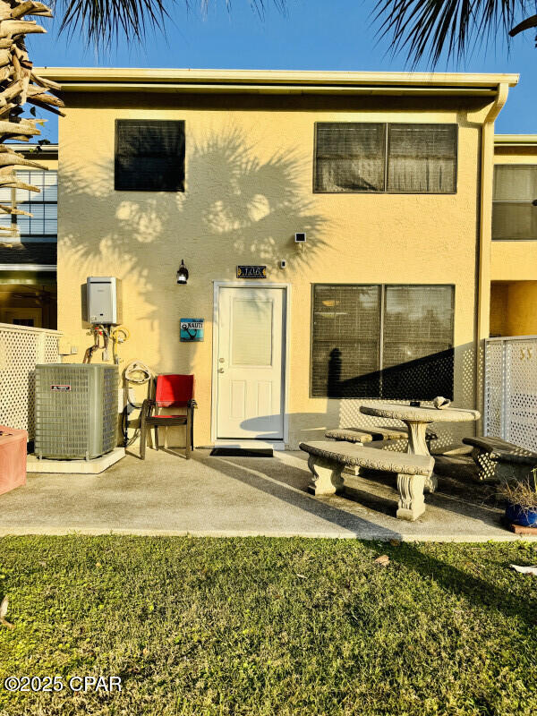 back of house featuring a lawn and cooling unit