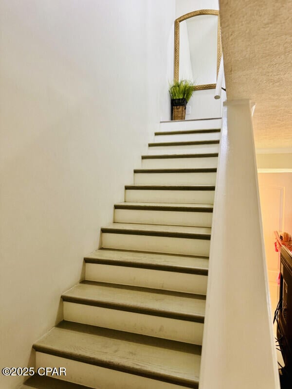 stairway featuring a textured ceiling