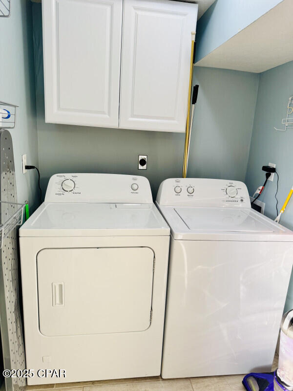 laundry room with washer and dryer and cabinets