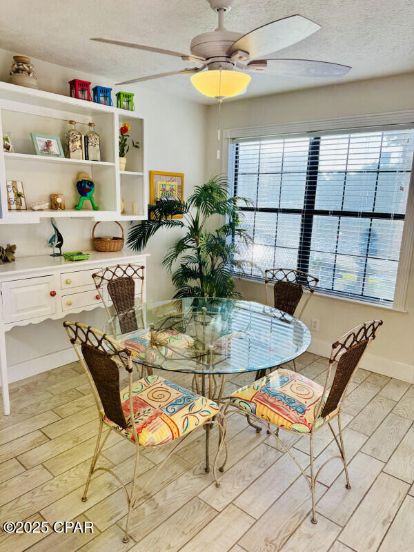 dining space with ceiling fan and a textured ceiling