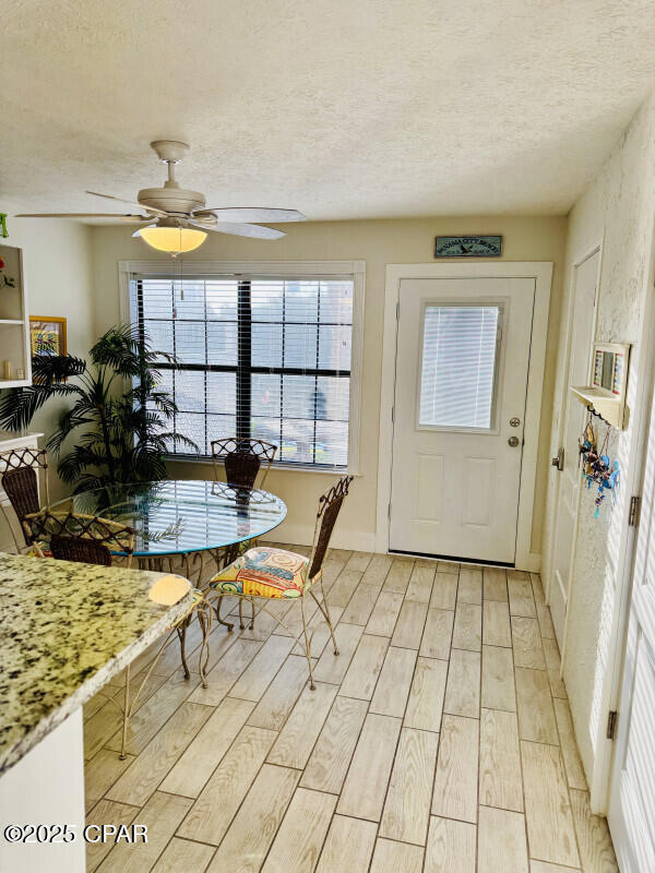 dining area with a textured ceiling and ceiling fan