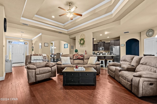 living room featuring a tray ceiling, ceiling fan, crown molding, and dark hardwood / wood-style floors