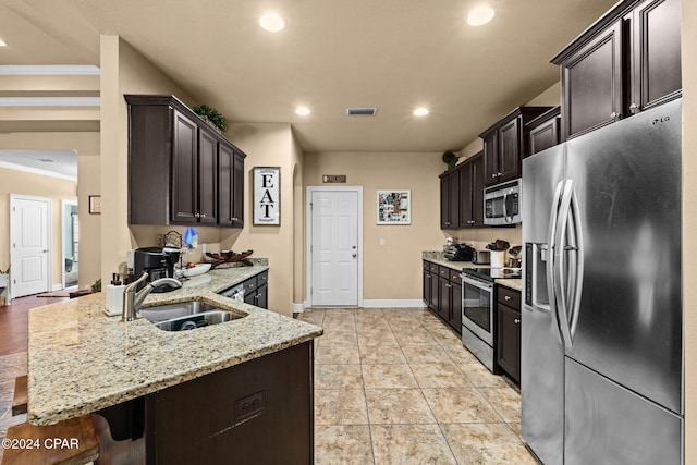 kitchen with a breakfast bar, sink, light stone countertops, appliances with stainless steel finishes, and light tile patterned flooring