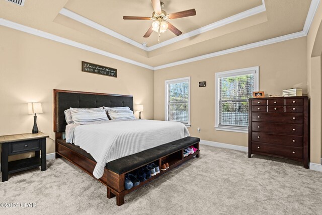 bedroom featuring a raised ceiling, ceiling fan, and light colored carpet