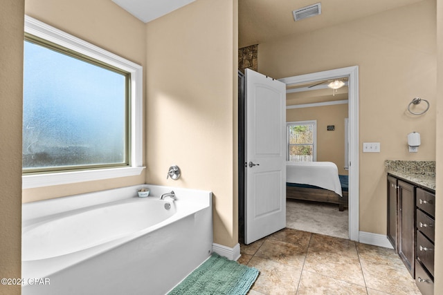 bathroom with vanity, tile patterned floors, plenty of natural light, and a bathing tub