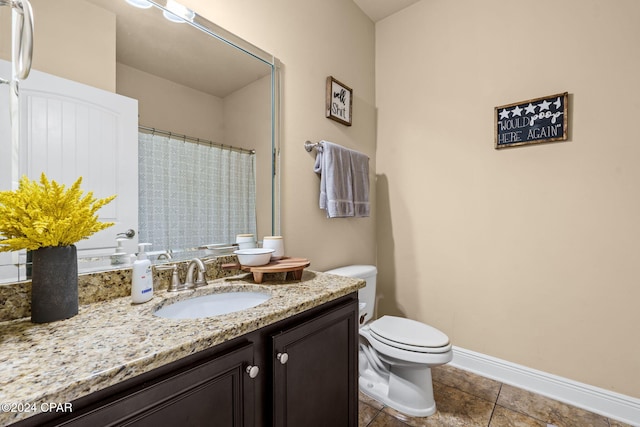 bathroom featuring tile patterned flooring, vanity, and toilet