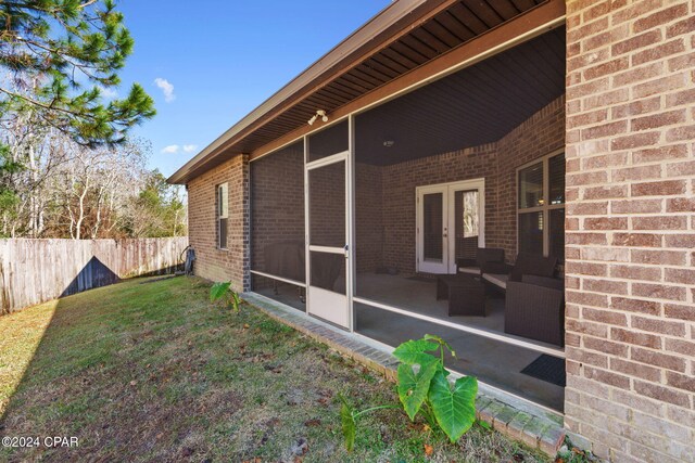 view of yard with french doors and a sunroom