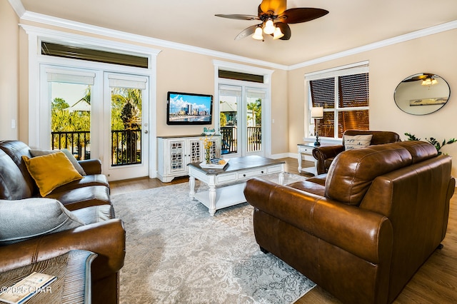 living room featuring a healthy amount of sunlight, light hardwood / wood-style flooring, ceiling fan, and ornamental molding