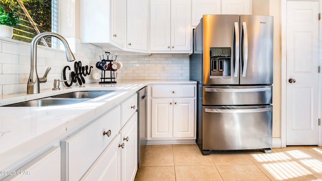 kitchen featuring light tile patterned flooring, white cabinetry, sink, and appliances with stainless steel finishes