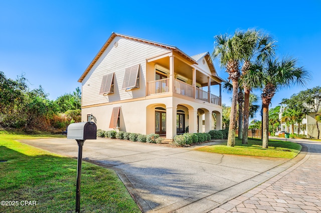 view of front of property featuring a balcony and a front yard